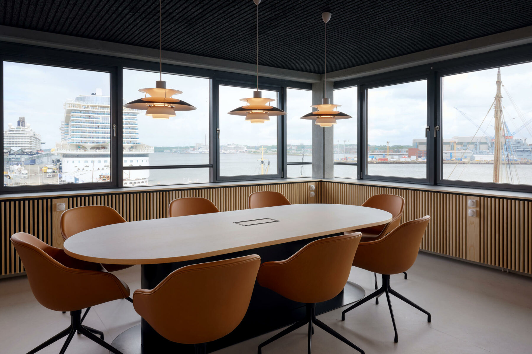 Beurkundungsraum mit speziell entworfenem Konferenztisch mit integriertem Kabelmanagement. Die Heizkörperverkleidungen mit Eschenholzstäben ziehen sich als Band durch die gesamte Etage.